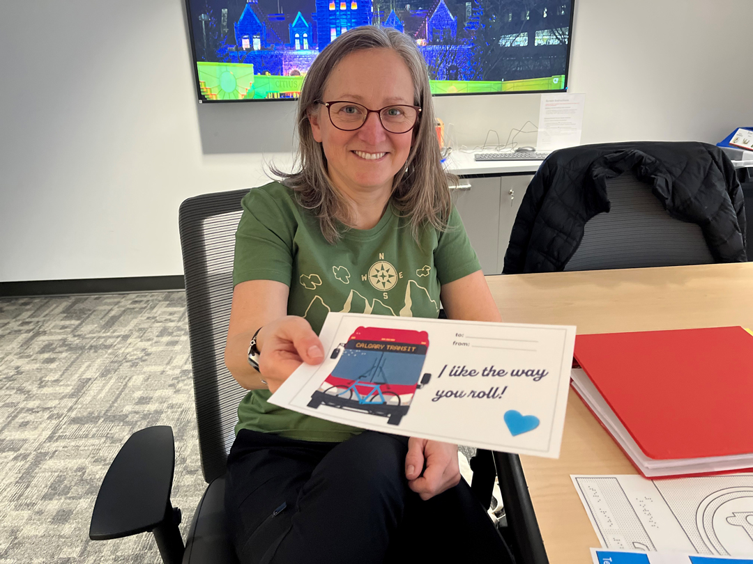 Woman holding a Calgary Transit themed Valentine's Day card